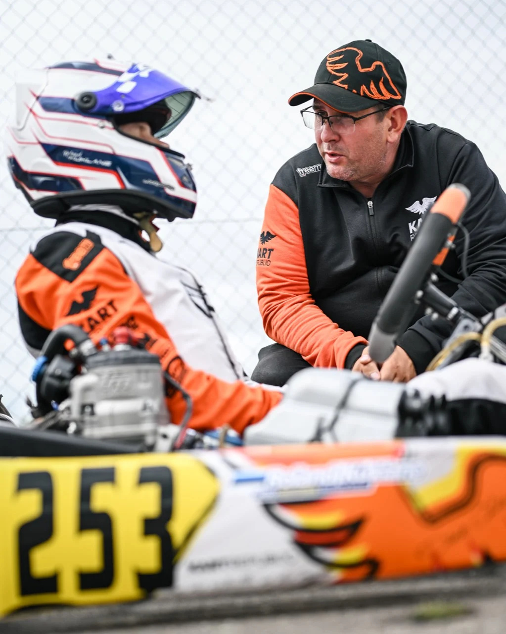 Andrei Bersenev discussing preparation with a driver beside the kart