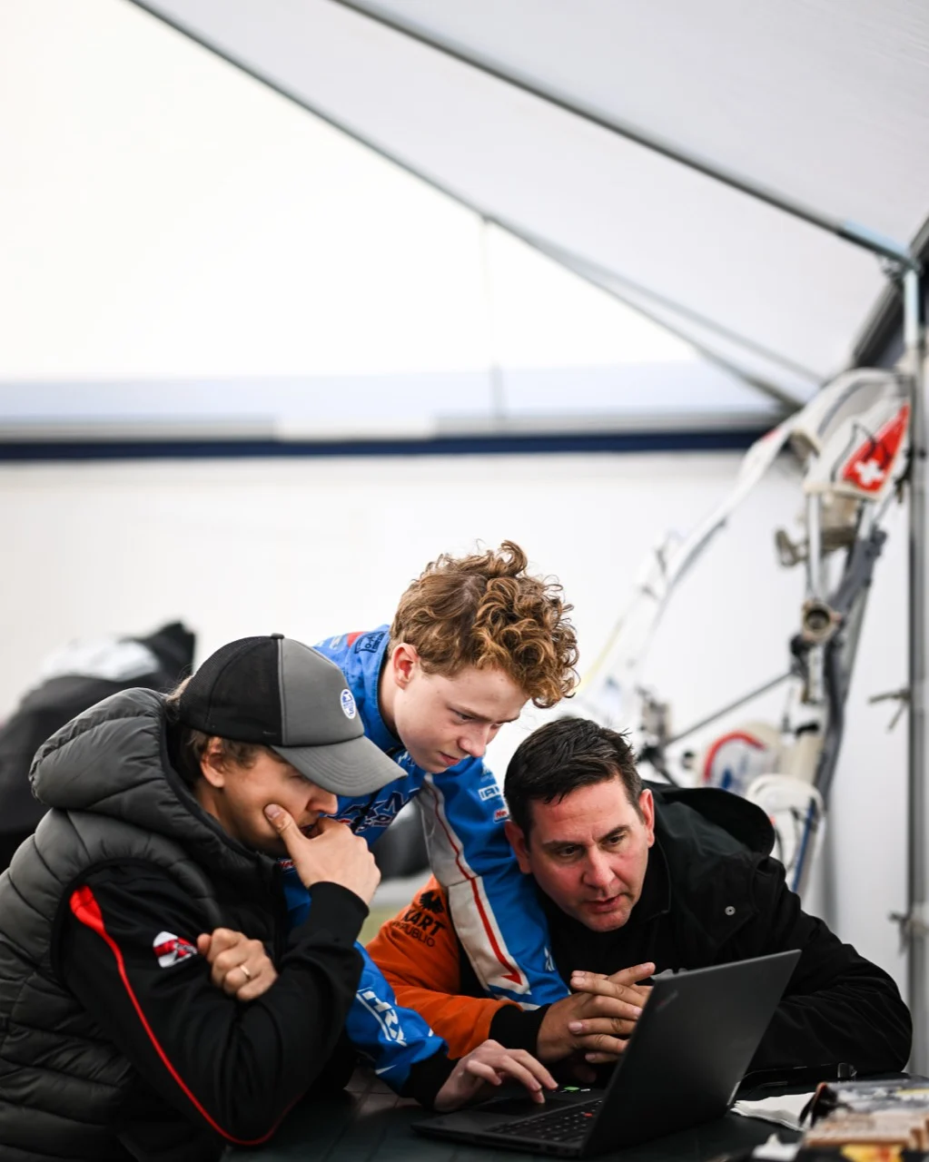 Driver, coach and team reviewing performance data